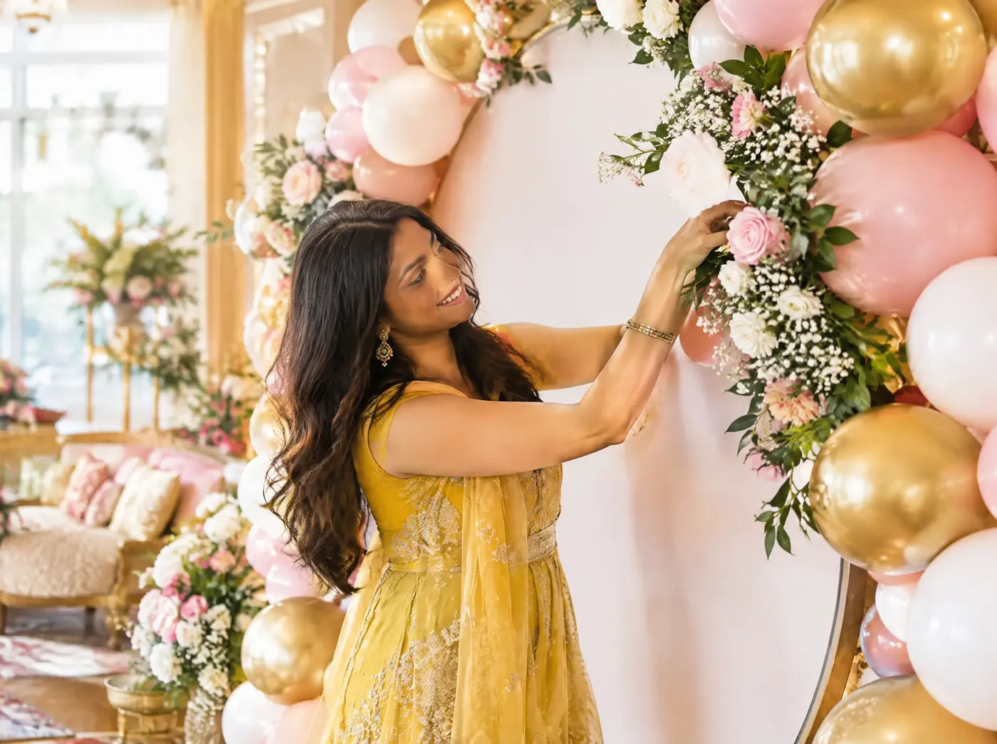 A woman decorating a balloon arch for a party